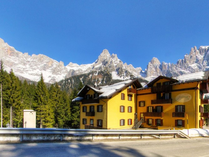 Hotel Fratazza - External view of the Hotel with snow-covered Dolomites in the background