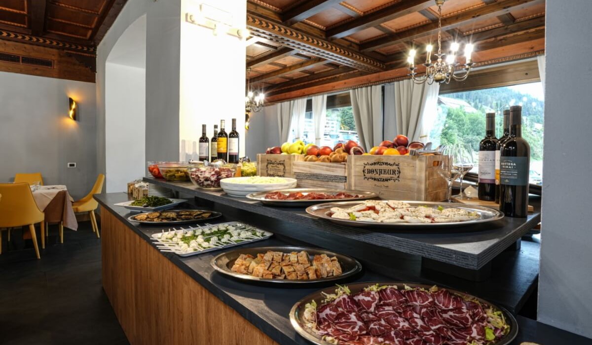 Hotel Monzoni - Rich buffet featuring local traditional fare with a wide selection of appetizers, fruits, and wine.

