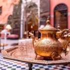 Traditional decorated copper teapot with glasses on a table in a venue in the Medina of Fes, Morocco