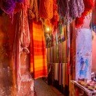 Sale of colorful scarves and fabrics with vibrant natural pigments in a souk in the Medina of Marrakech