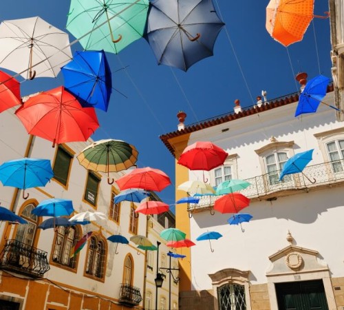 Évora, a typical city square covered with floating colorful umbrellas