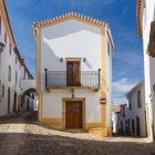 The medieval streets with characteristic cobblestones and white houses accented with colorful details in the town of Marvão, Portugal