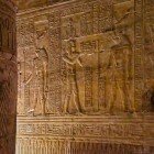 Ancient Egyptian hieroglyphs carved on the walls and sandstone columns in the Temple of Edfu in Egypt