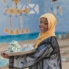 A nubian girl serving tea, with very particular and distinctive features, including dark skin and light-colored eyes, often green, hazel, or even blue