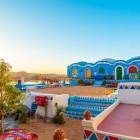 Sunrise view of a Nubian house characterized by the vibrant shimmering blue color