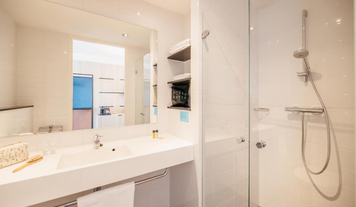 Hotel Casa Amsterdam - The bathroom with shower is designed to offer a combination of elegance and practicality