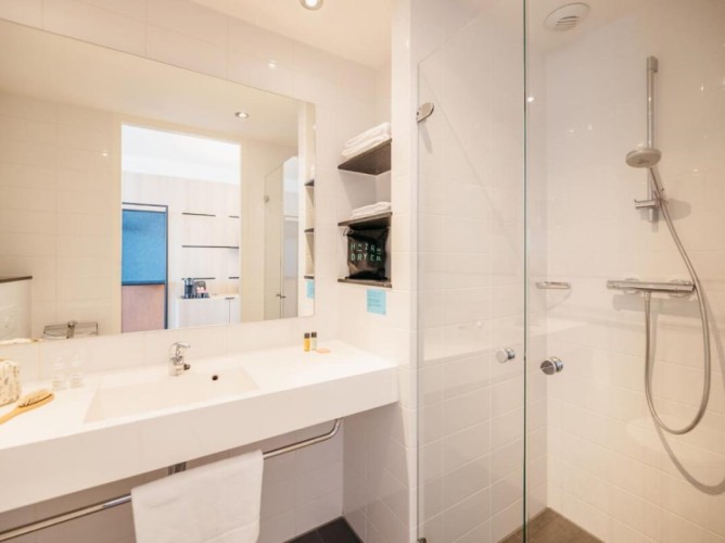 Hotel Casa Amsterdam - The bathroom with shower is designed to offer a combination of elegance and practicality