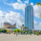 Port and Olympic Village of Barcelona with one of the two towers and the sculpture El Peix, also known as the Golden Fish, in the background