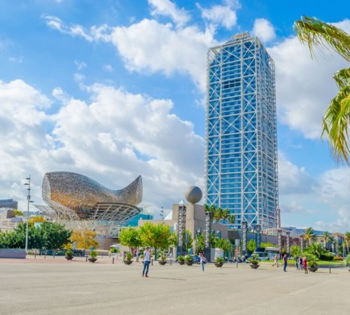 Port and Olympic Village of Barcelona with one of the two towers and the sculpture El Peix, also known as the Golden Fish, in the background