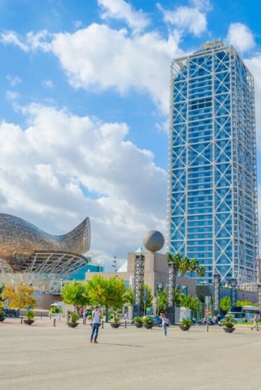 Port and Olympic Village of Barcelona with one of the two towers and the sculpture El Peix, also known as the Golden Fish, in the background